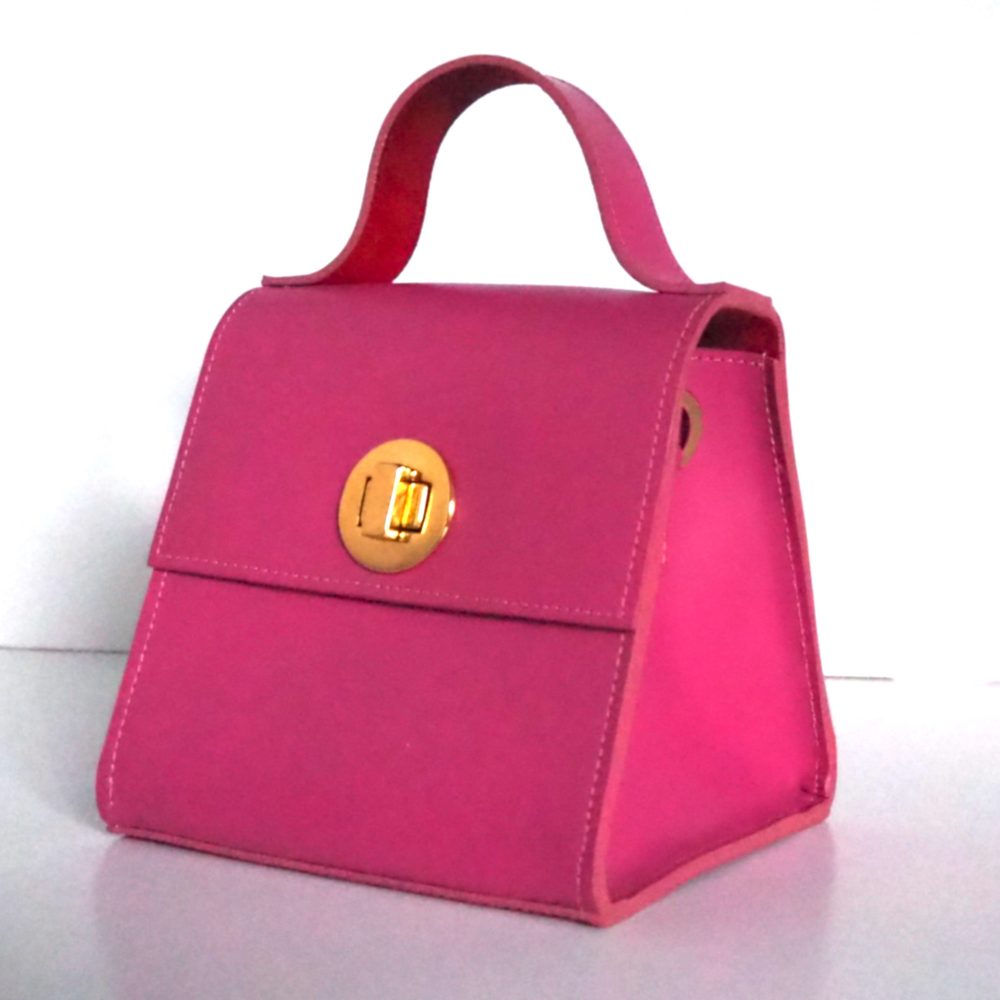 Side view of a berry pink small designer bag with an inner red lining