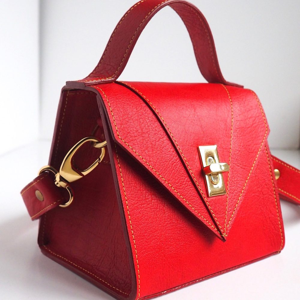 Side view of a red mini designer handbag handmade in London